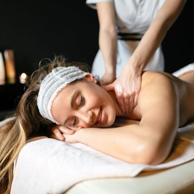 Massage therapist massaging beautiful brunette